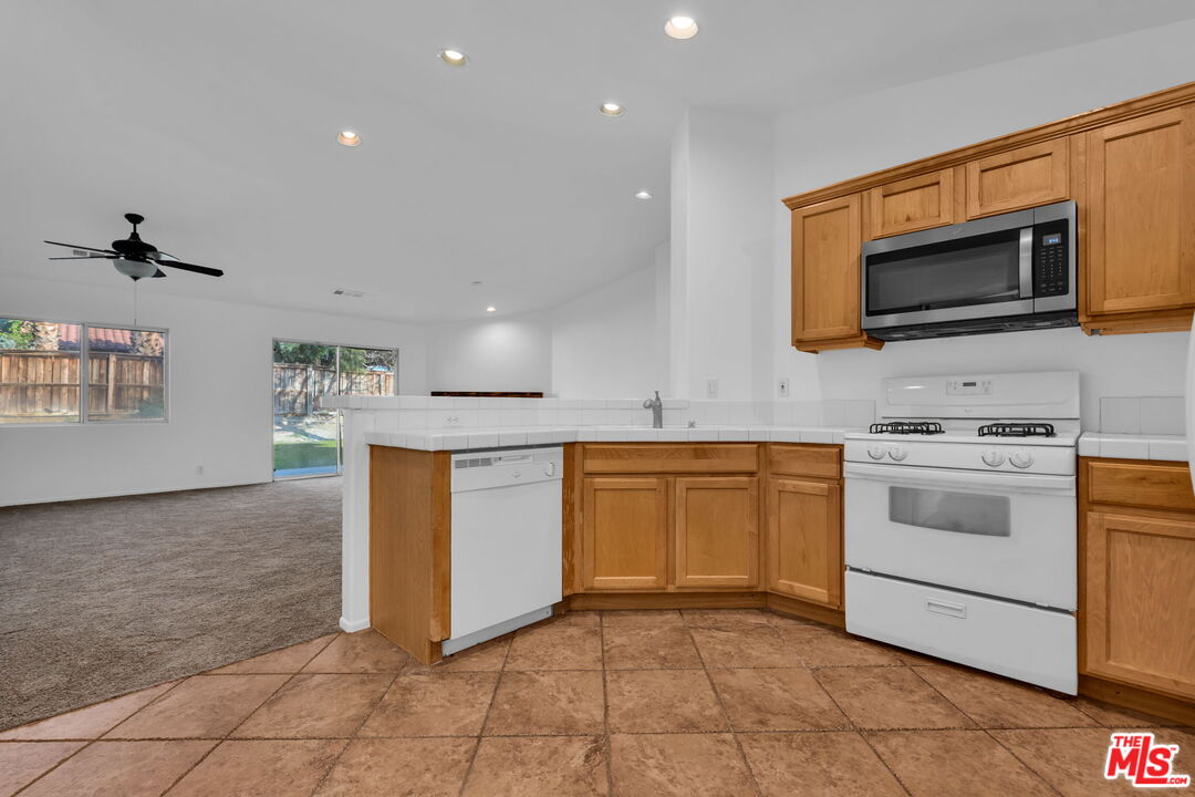 30940 Robert Road Thousand Palms, CA 92276 - Photo 21 of 48 a kitchen with stainless steel appliances granite countertop a stove a microwave and a sink