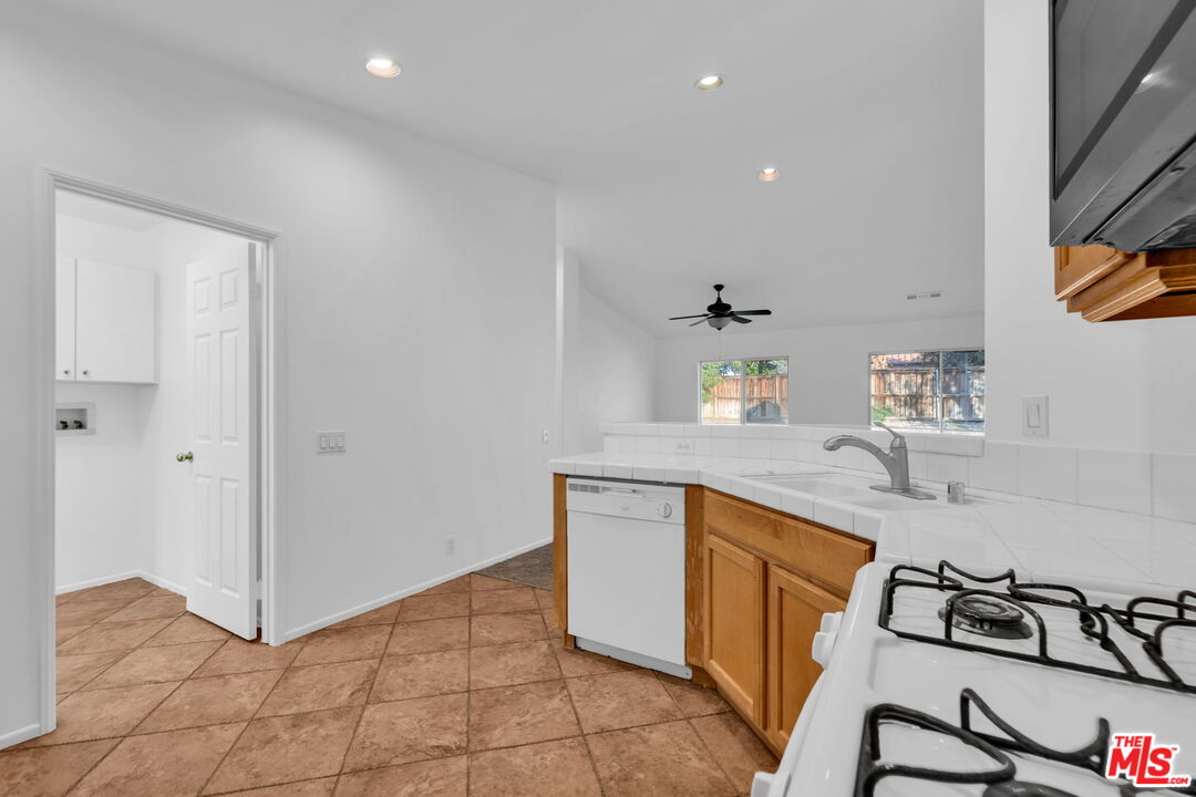 30940 Robert Road Thousand Palms, CA 92276 - Photo 22 of 48 a kitchen with stainless steel appliances granite countertop a sink and cabinets
