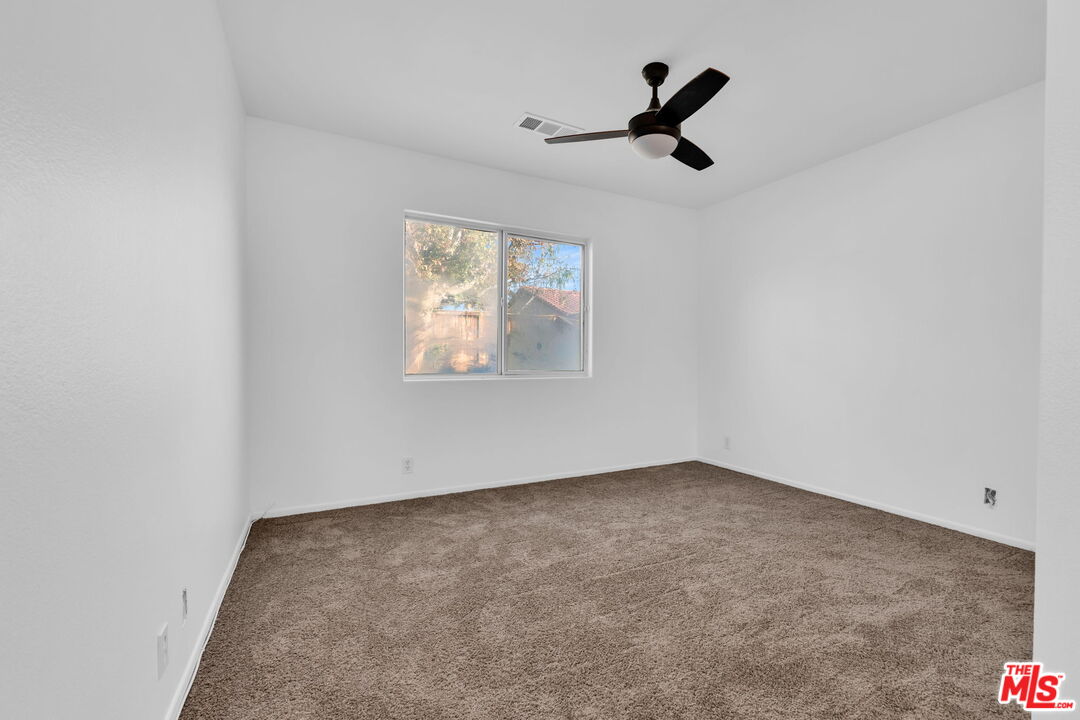 30940 Robert Road Thousand Palms, CA 92276 - Photo 10 of 48 an empty room with ceiling fan and window