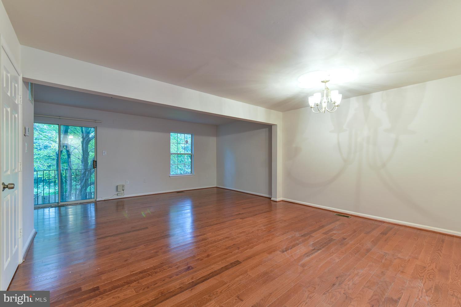 6507 Ronald Road Capitol Heights, MD 20743 - Photo 8 of 30 an empty room with wooden floor chandelier and windows
