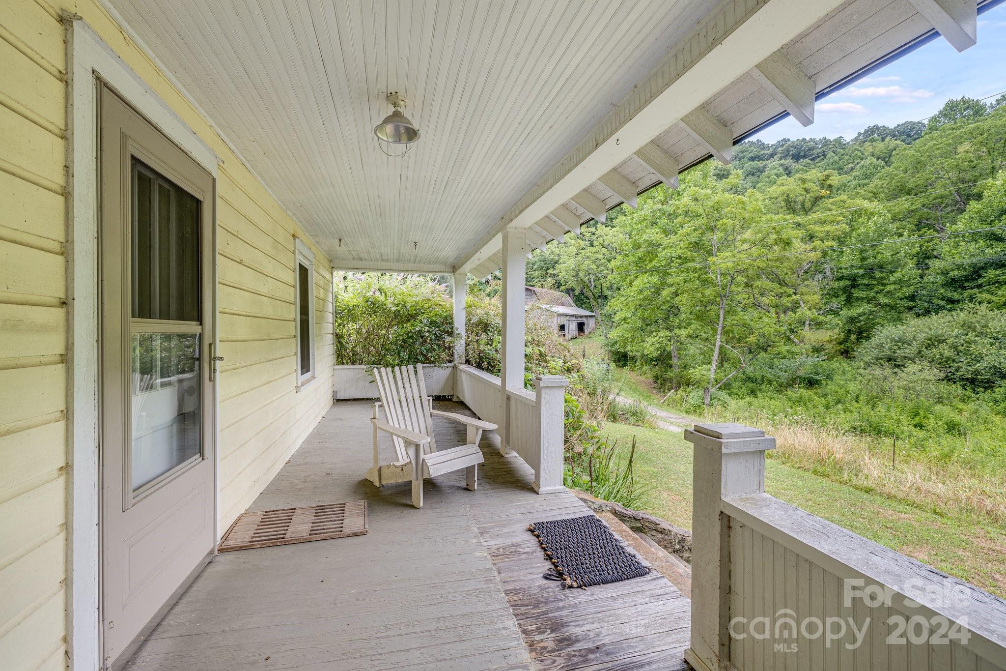71 Persimmon Lane Canton, NC 28716 - Photo 16 of 41 a view of a porch with furniture and garden