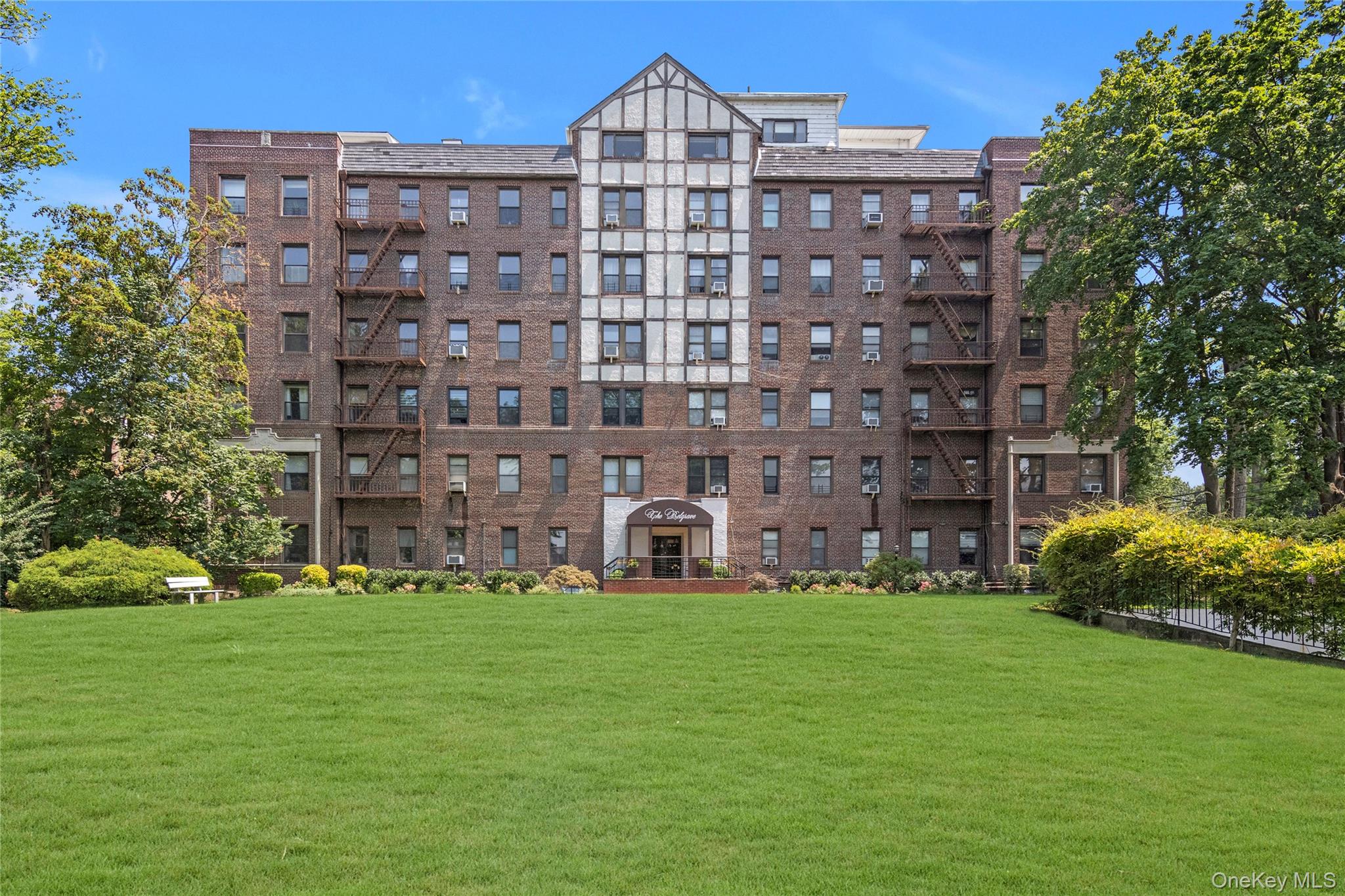 37 Brompton Road, Unit 5D Great Neck, NY 11021 - Photo 1 of 1 a large building with a yard in front of it