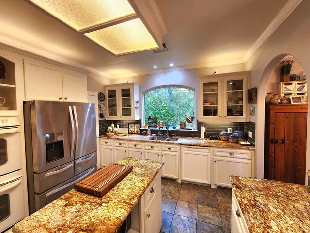 a kitchen with stainless steel appliances granite countertop a refrigerator and a stove top oven