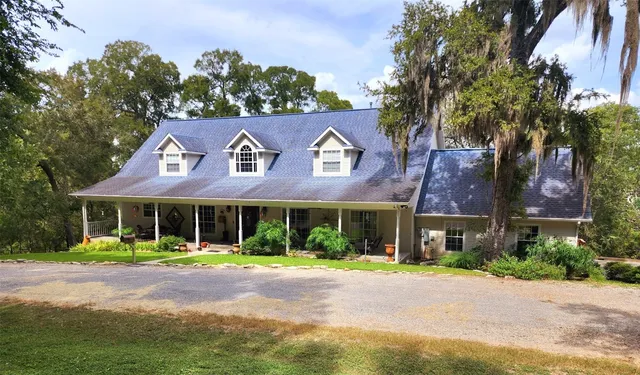 a front view of a house with a yard and trees
