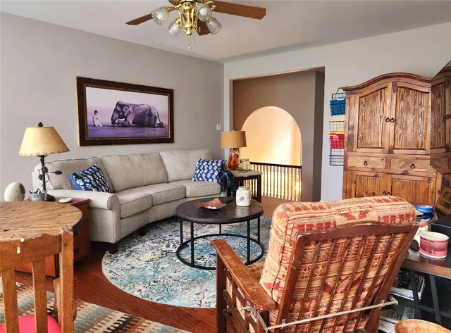 a living room with furniture a table and kitchen view
