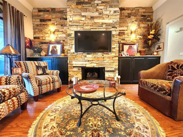 a living room with furniture a flat screen tv and a fireplace