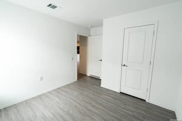 a view of an empty room with wooden floor