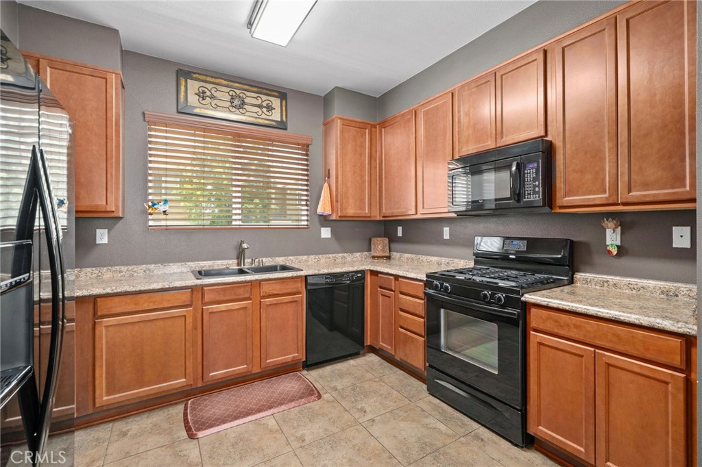 33942 Telstar Road Yucaipa, CA 92399 - Photo 15 of 40 a kitchen with stainless steel appliances granite countertop wooden cabinets stove top oven and sink