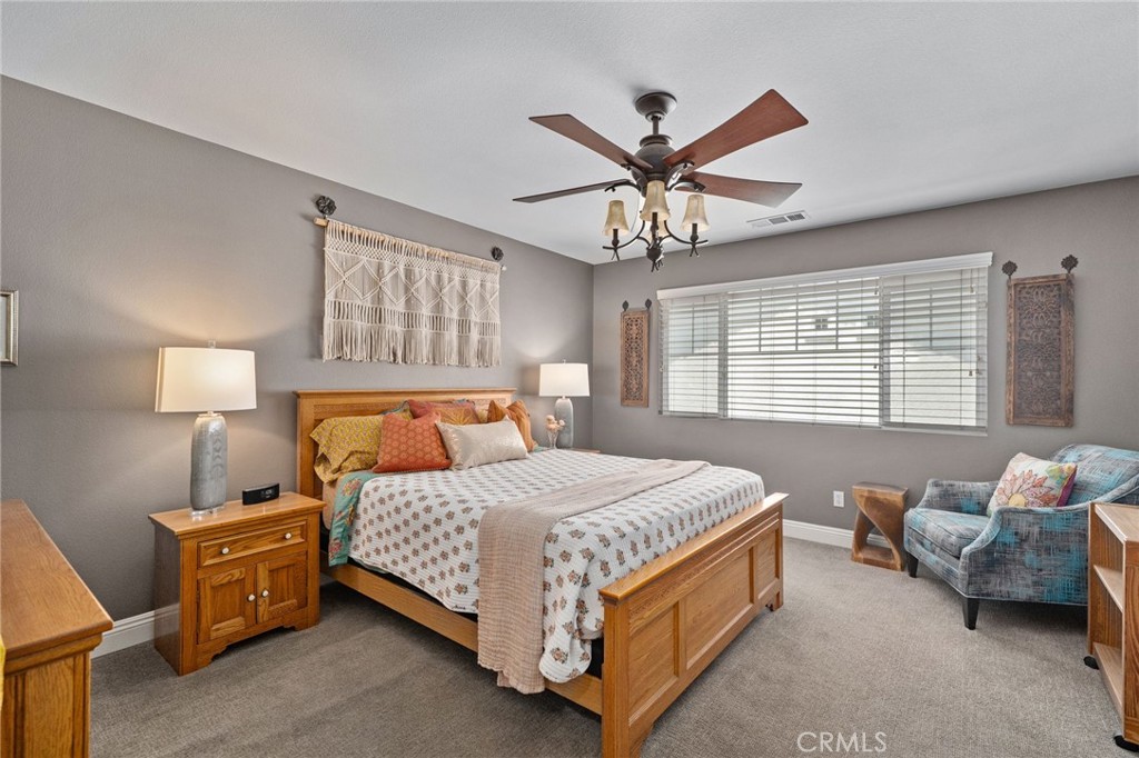 33942 Telstar Road Yucaipa, CA 92399 - Photo 17 of 40 a bedroom with a bed and a chandelier