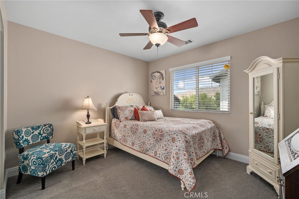 33942 Telstar Road Yucaipa, CA 92399 - Photo 22 of 40 a bedroom with a bed and a chandelier