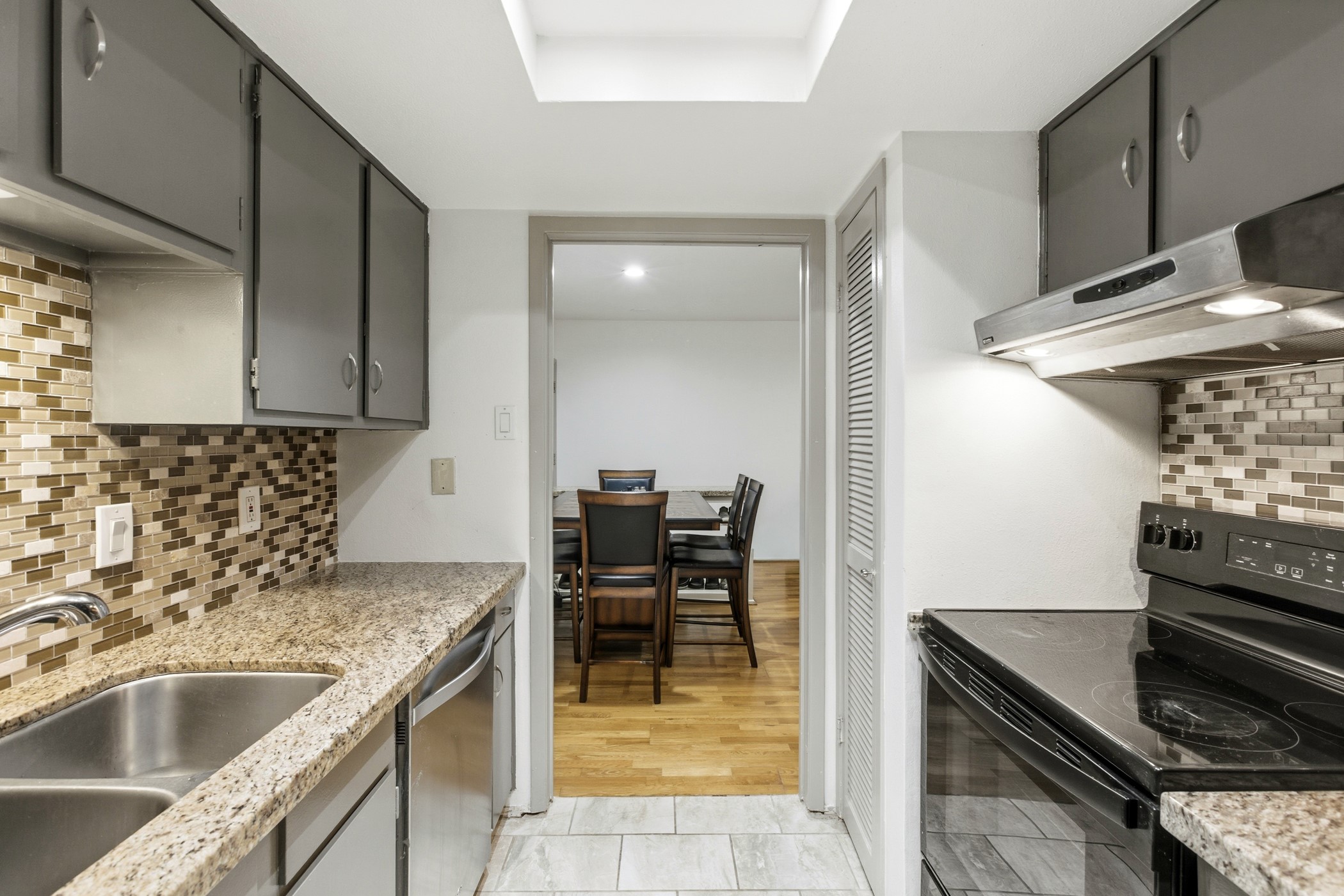 2224 South Piney Point Road, Unit 222 Houston, TX 77063 - Photo 16 of 28 a kitchen with granite countertop a sink and a stove top oven