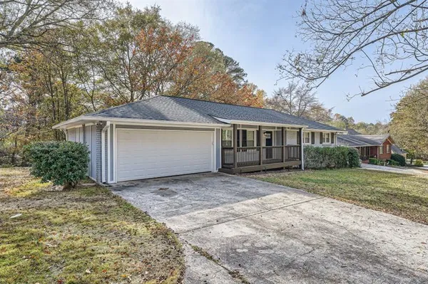 a front view of house with yard and trees around