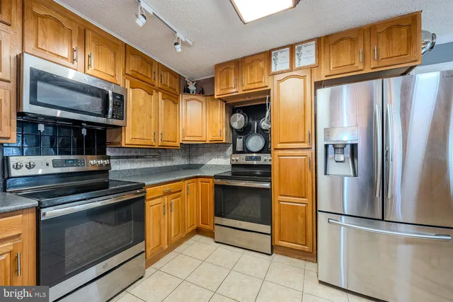 a kitchen with stainless steel appliances granite countertop a refrigerator stove and sink
