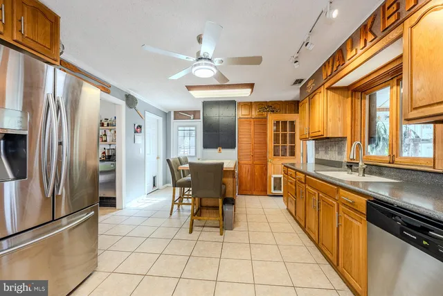 a kitchen with stainless steel appliances granite countertop a refrigerator and a sink