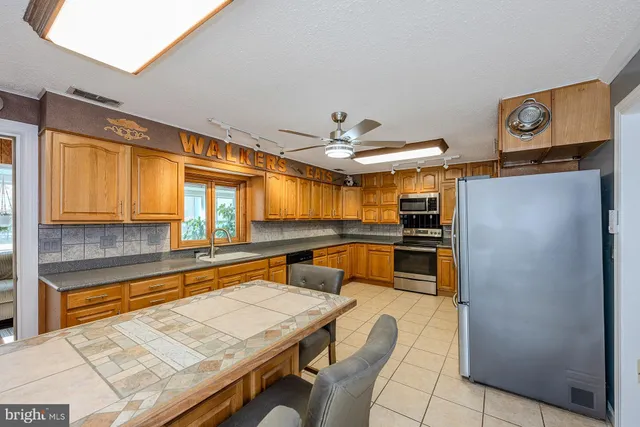 a kitchen with stainless steel appliances granite countertop a refrigerator and a stove top oven