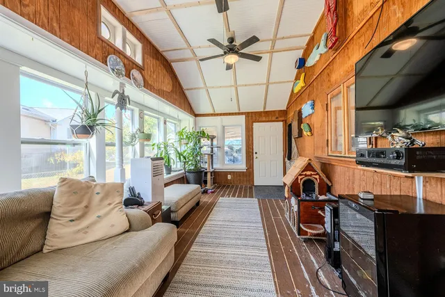 a living room with furniture a wooden floor and a large window