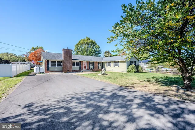 a view of a house with a yard and large trees
