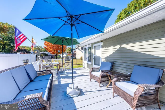 a view of a patio with couches chairs under an umbrella
