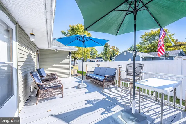 a view of a patio with a dining table and chairs under an umbrella