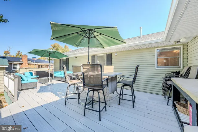 a view of a roof deck with table and chairs under an umbrella