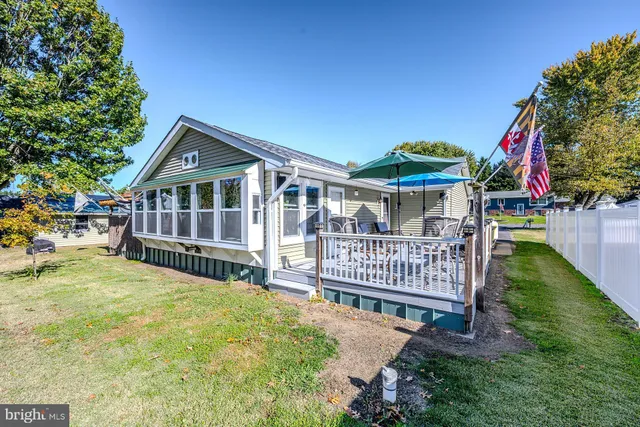 a view of a house with a wooden deck and a yard
