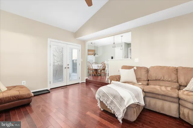 a living room with a bed furniture and a wooden floor