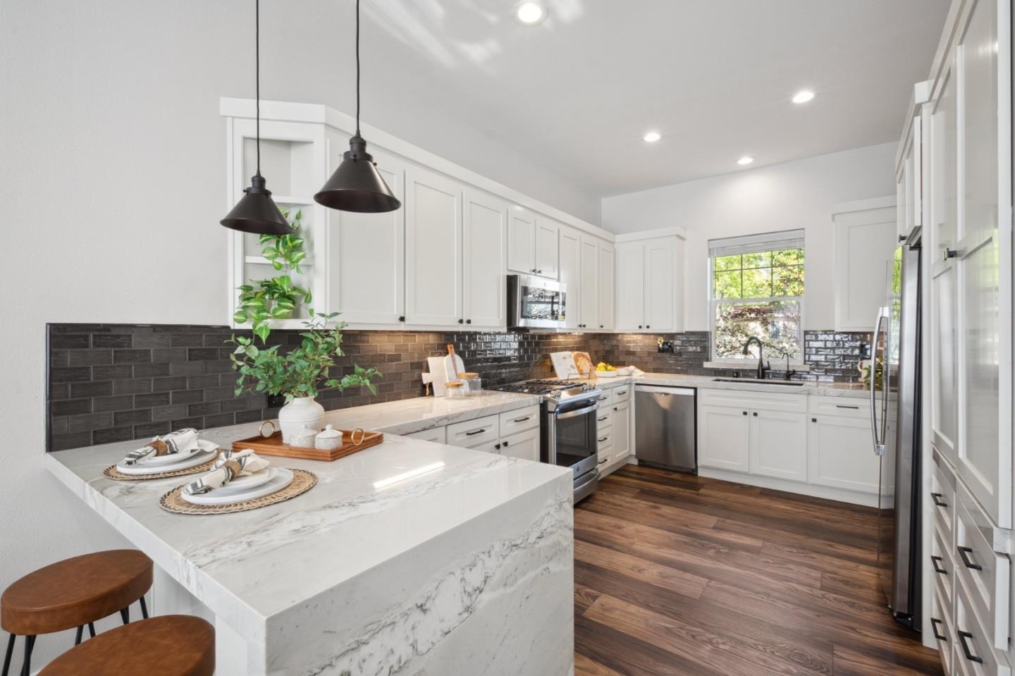 7531 Edinburgh Way Gilroy, CA 95020 - Photo 11 of 52 a kitchen with a sink dishwasher a stove a dining table and chairs with wooden floor
