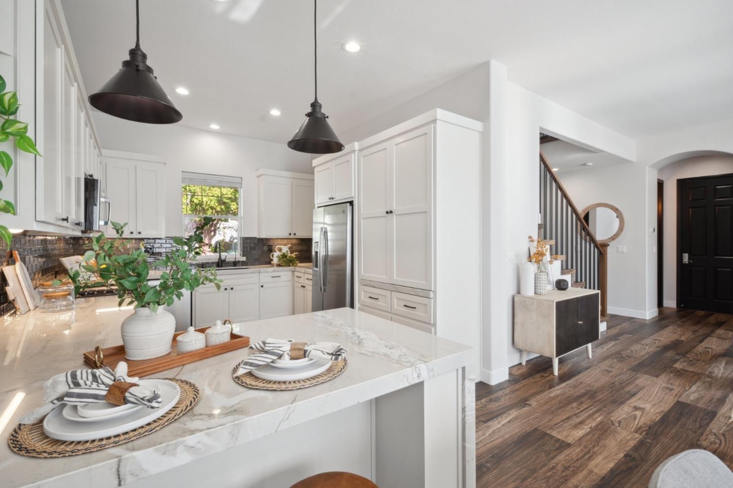 7531 Edinburgh Way Gilroy, CA 95020 - Photo 12 of 52 a kitchen with stainless steel appliances kitchen island granite countertop a table and chairs in it
