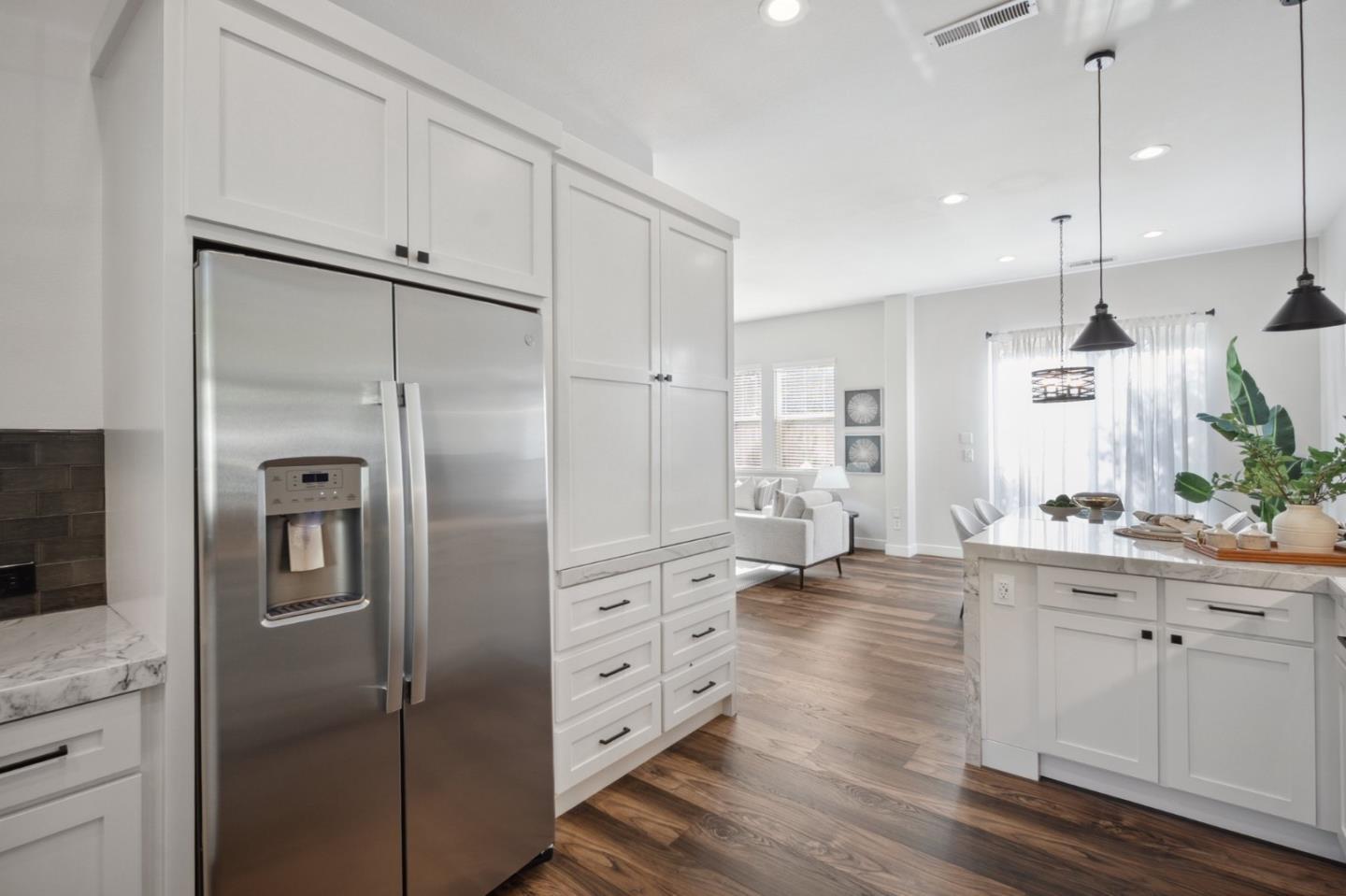 7531 Edinburgh Way Gilroy, CA 95020 - Photo 14 of 52 a kitchen with stainless steel appliances kitchen island a refrigerator and cabinets