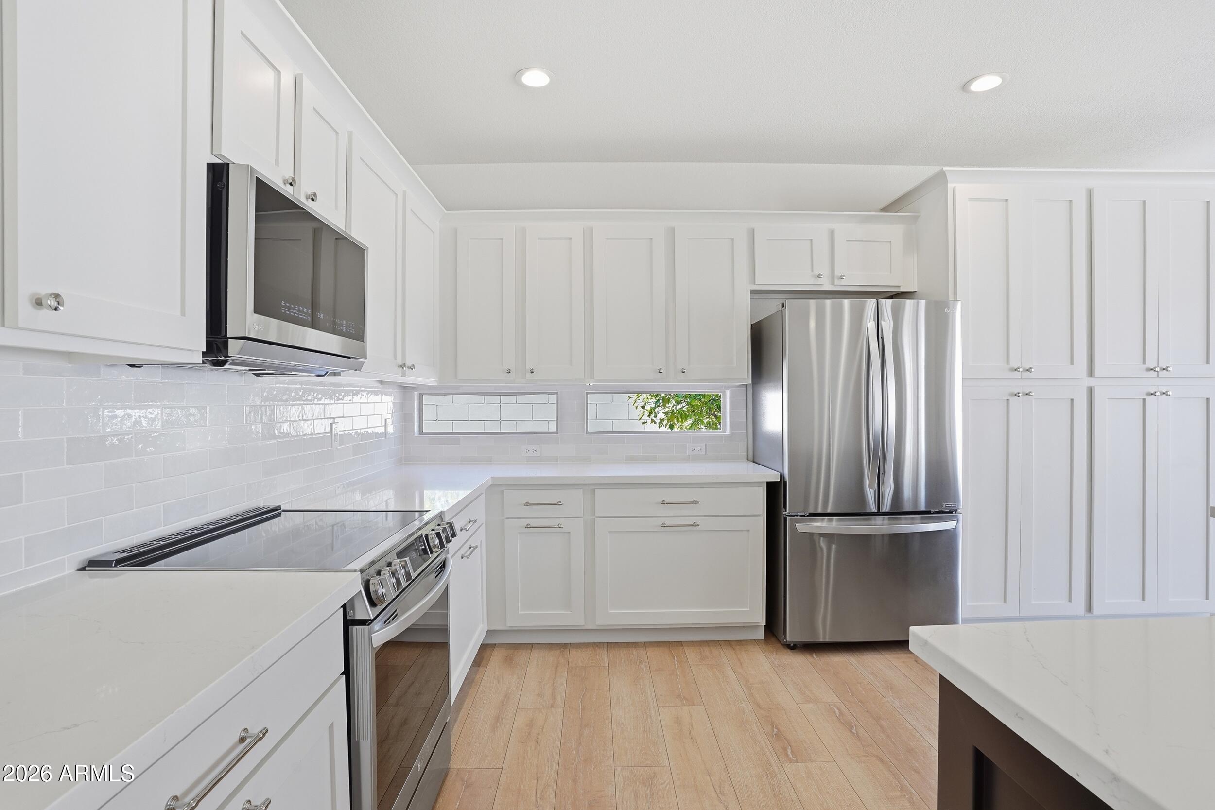 3262 East Cotton Lane Gilbert, AZ 85234 - Photo 14 of 53 a kitchen with granite countertop a refrigerator sink and microwave