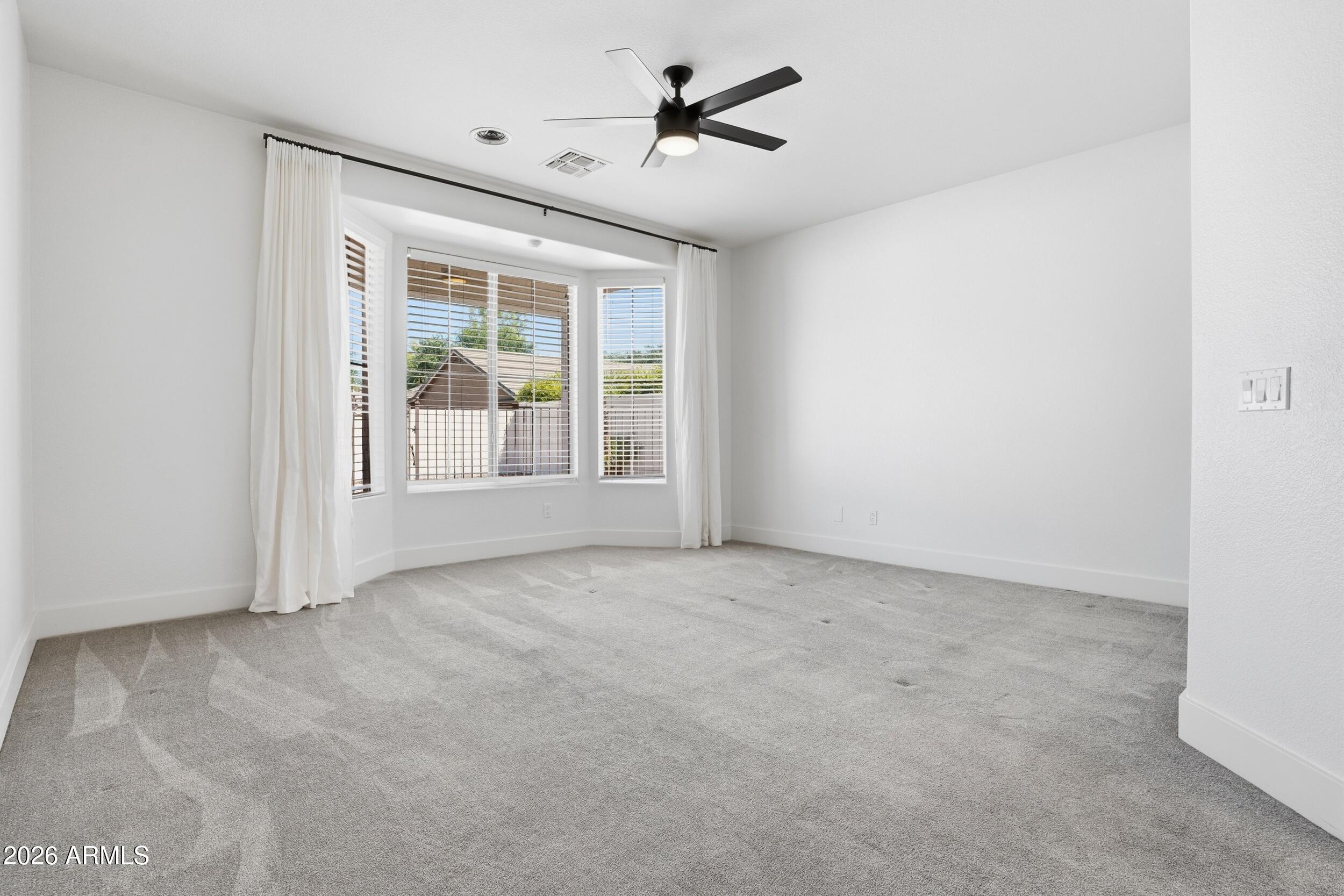 3262 East Cotton Lane Gilbert, AZ 85234 - Photo 18 of 53 an empty room with windows and fan