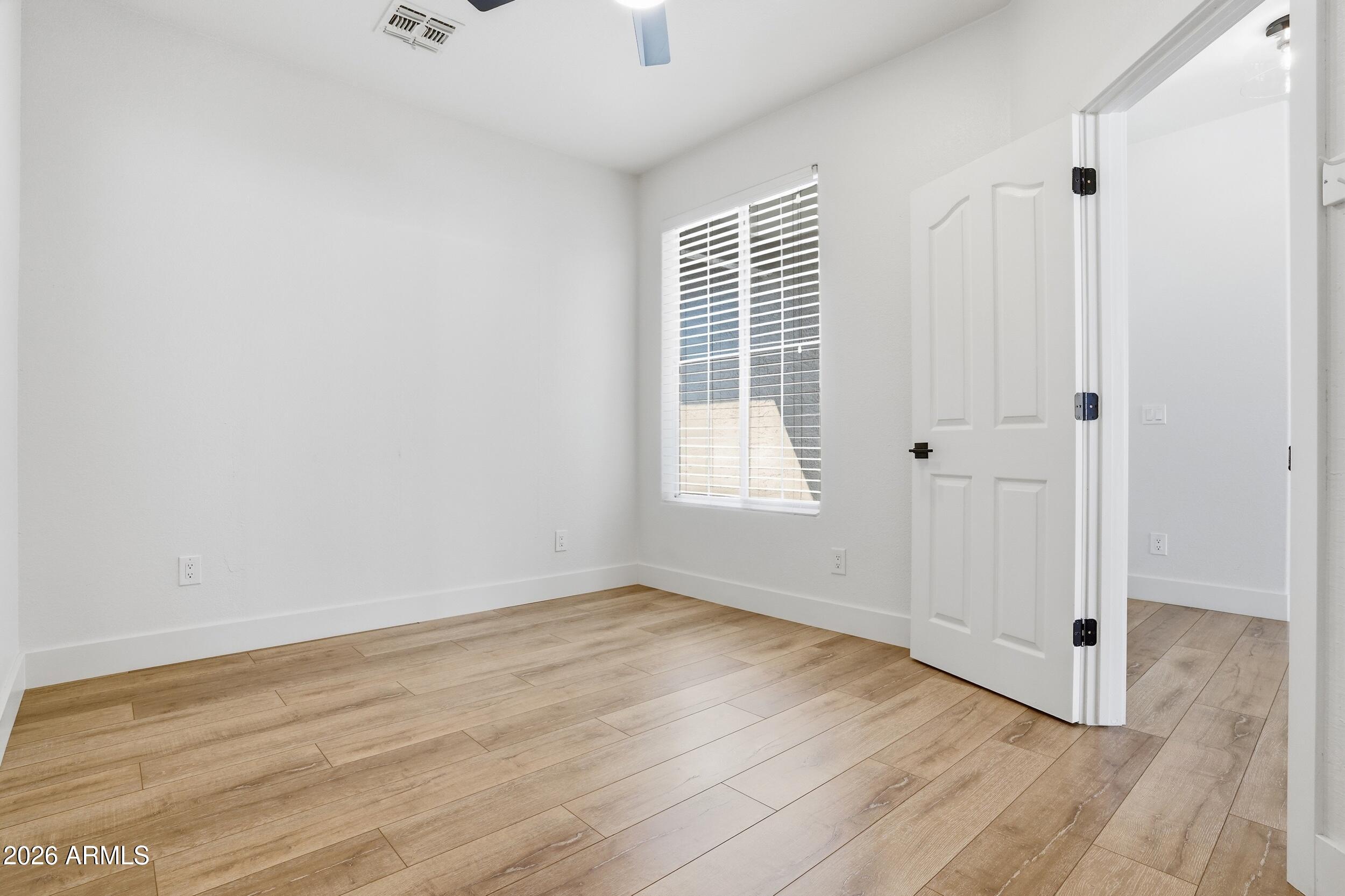 3262 East Cotton Lane Gilbert, AZ 85234 - Photo 28 of 53 an empty room with wooden floor and windows