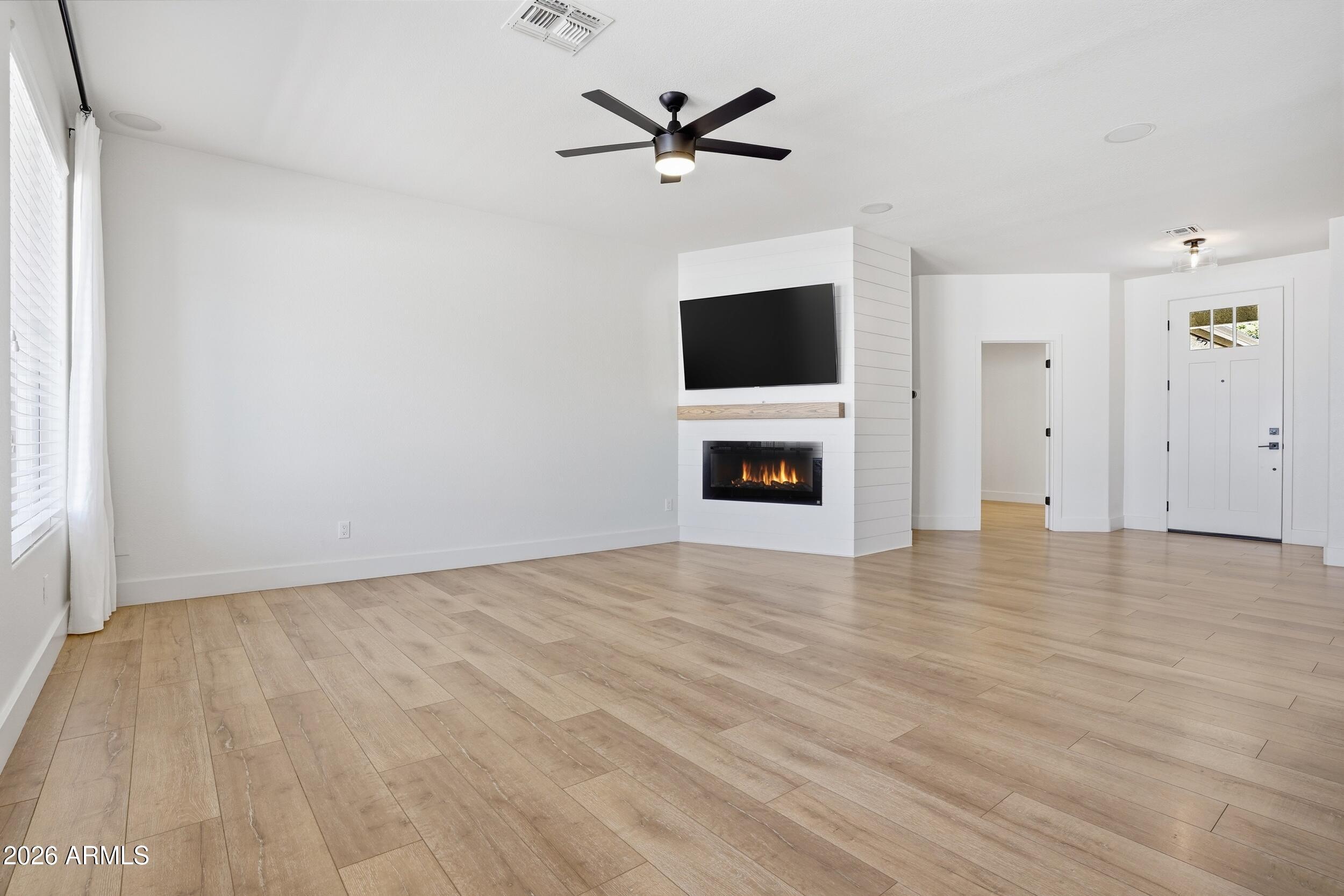 3262 East Cotton Lane Gilbert, AZ 85234 - Photo 9 of 53 a view of a livingroom with a fireplace a ceiling fan and wooden floor