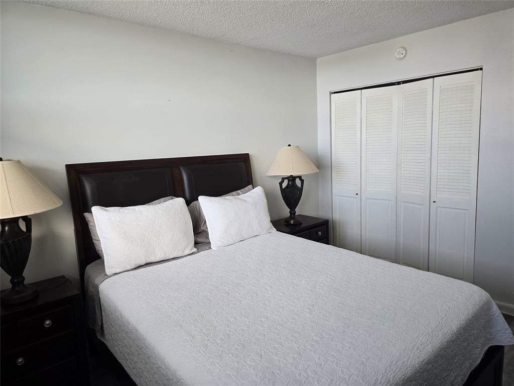 1401 North Riverside Drive, Unit 705 Pompano Beach, FL 33062 - Photo 13 of 30 a large bed sitting in a bedroom next to a lamp