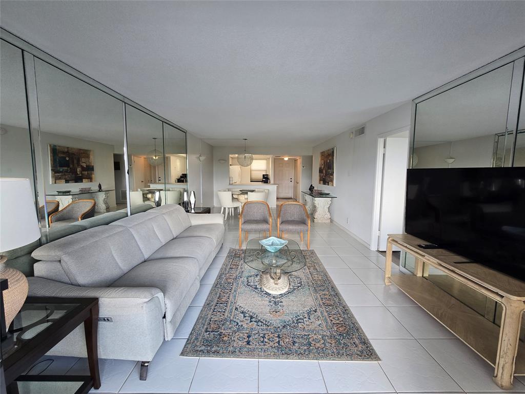 1401 North Riverside Drive, Unit 705 Pompano Beach, FL 33062 - Photo 3 of 30 a living room with furniture and a flat screen tv