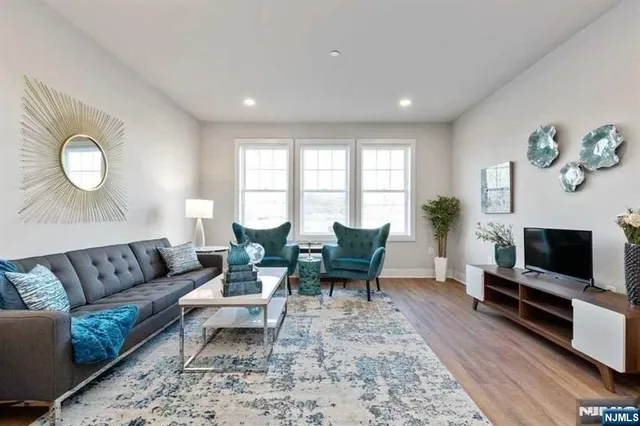 a living room with furniture a flat screen tv and a fireplace