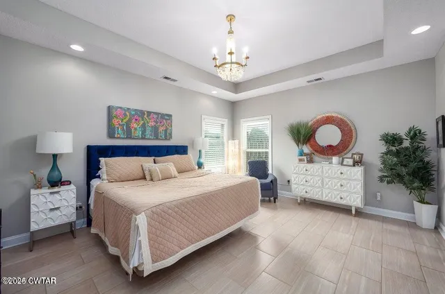 a bedroom with a bed and a chandelier