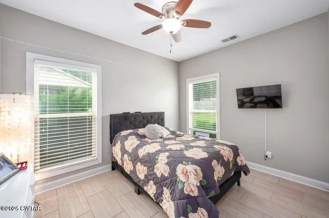 a bedroom with a bed tv and a window