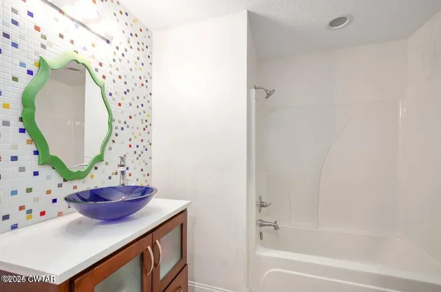 a bathroom with a sink a mirror and a shower curtain