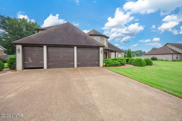 a front view of a house with a yard and garage