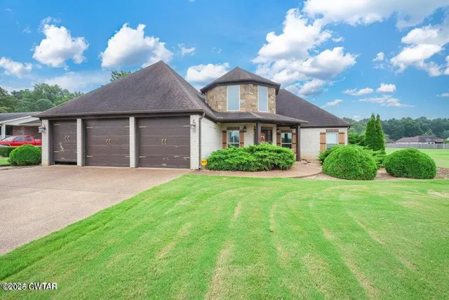 a front view of a house with a garden and plants