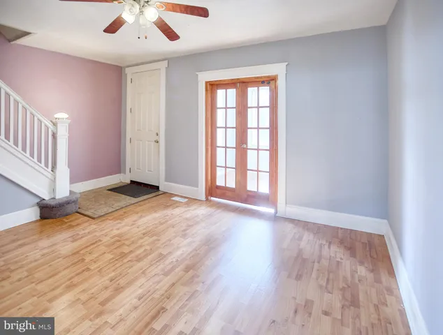 an empty room with wooden floor and windows