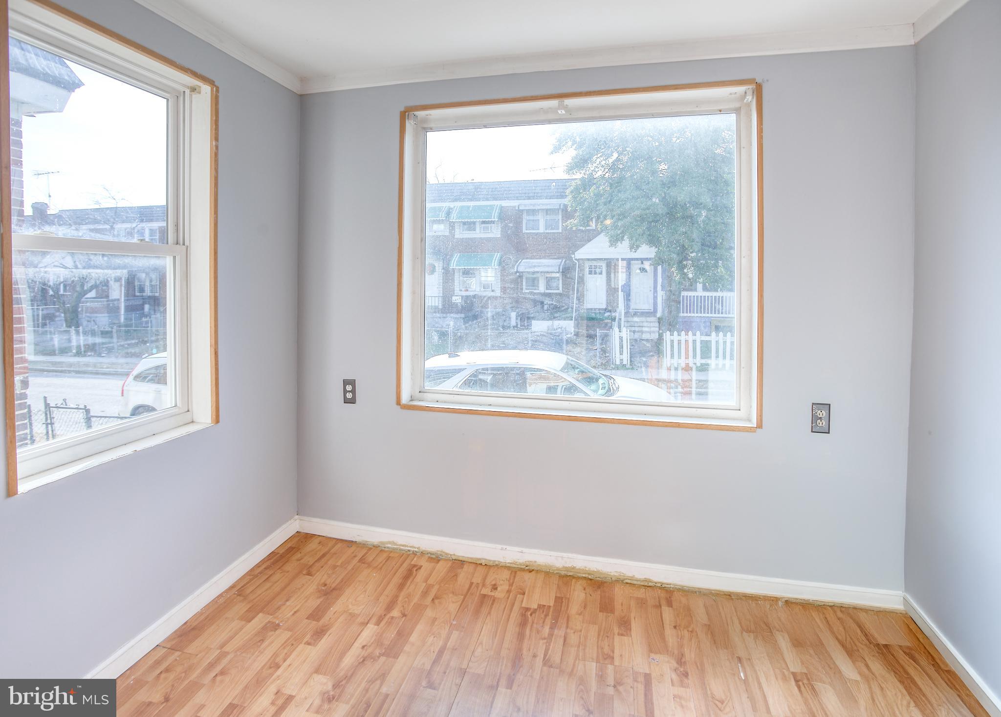 1332 Cambria Street Baltimore, MD 21225 - Photo 6 of 31 a view of an empty room with wooden floor and a window