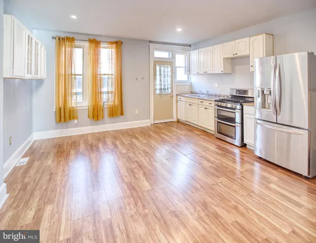 a kitchen with granite countertop wooden floors and stainless steel appliances