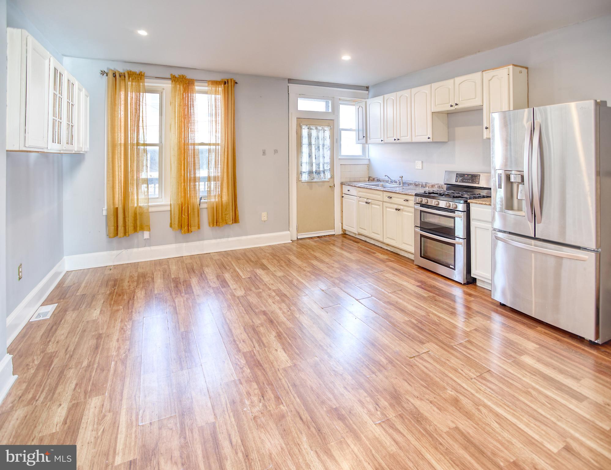 1332 Cambria Street Baltimore, MD 21225 - Photo 9 of 31 a kitchen with granite countertop wooden floors and stainless steel appliances