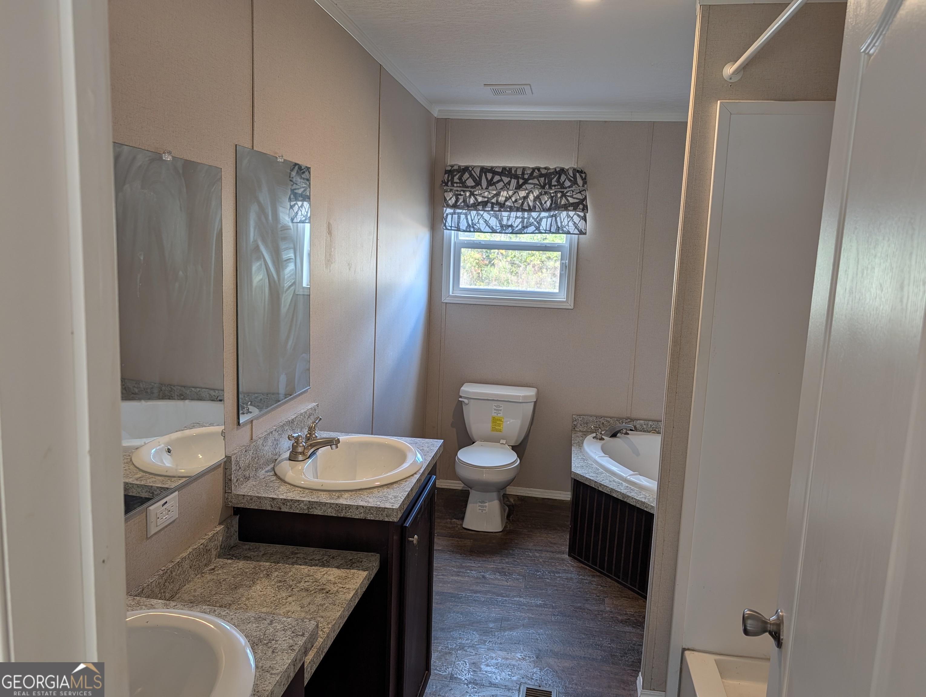 675 Fir Street Jesup, GA 31546 - Photo 14 of 22 a bathroom with a granite countertop toilet a sink and a mirror