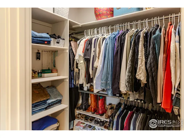 a view of walk in closet with clothes and shoes