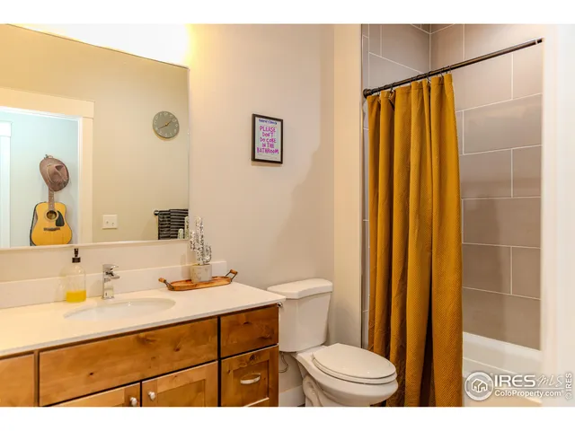 a bathroom with a sink a toilet a mirror and shower