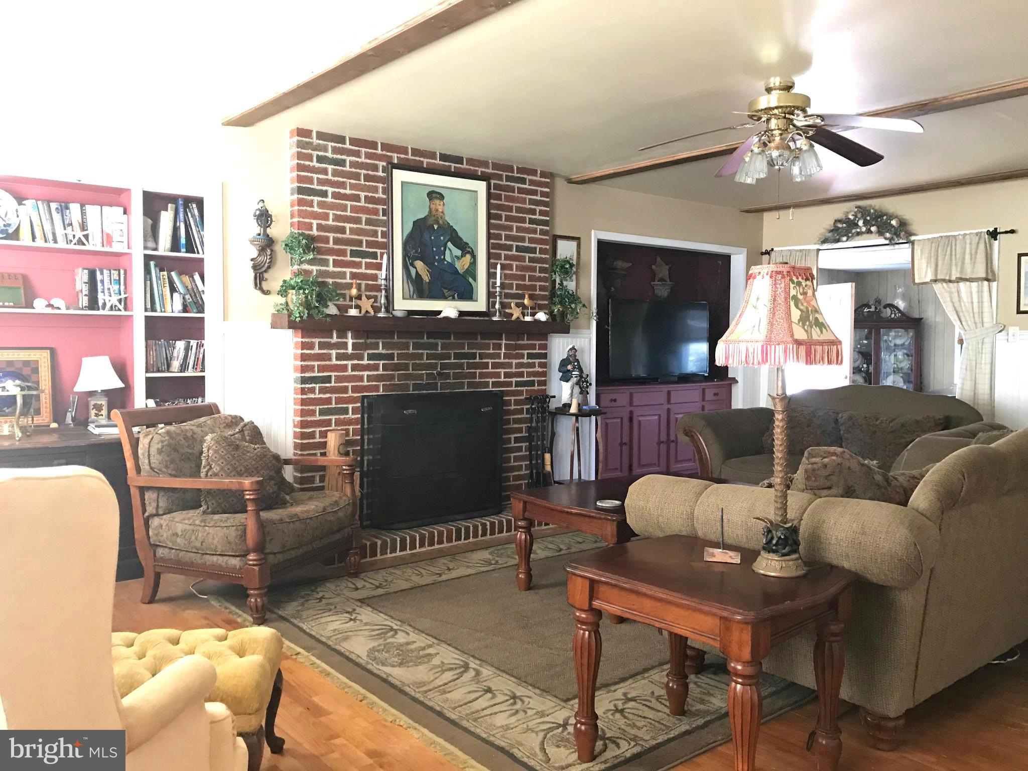 4416 Whalerman Road Brigantine, NJ 08203 - Photo 12 of 22 a living room with furniture a flat screen tv and a fireplace