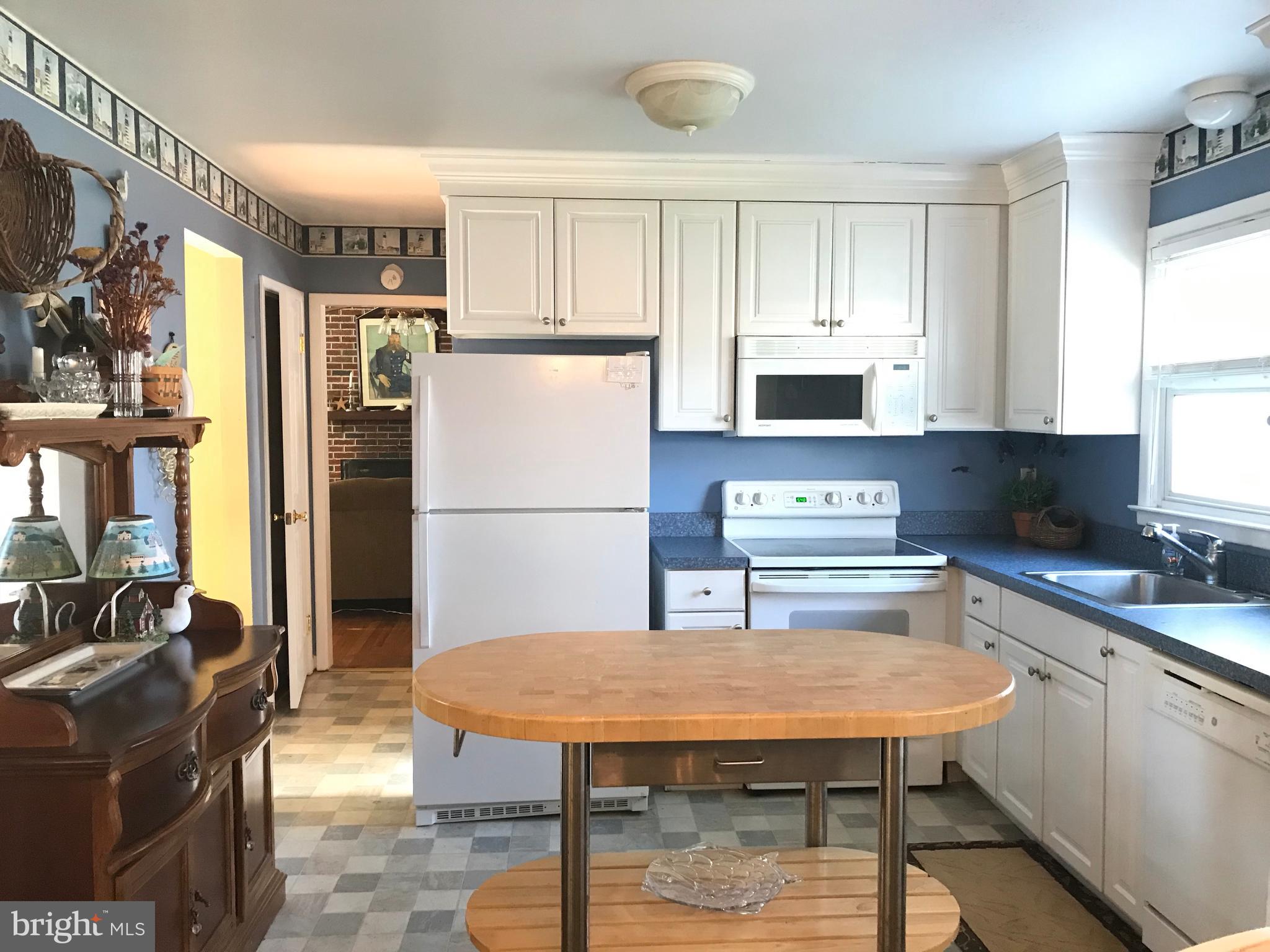 4416 Whalerman Road Brigantine, NJ 08203 - Photo 9 of 22 a kitchen with stainless steel appliances granite countertop a refrigerator a stove top oven a sink dishwasher and white cabinets